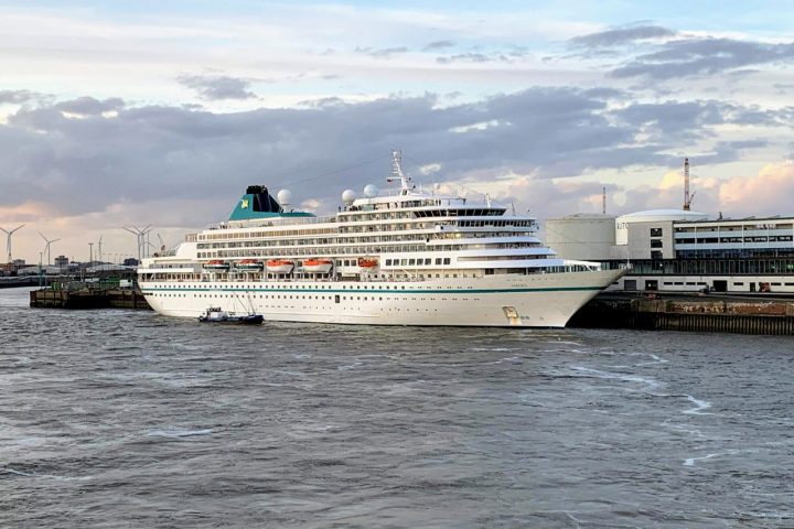 A large cruise ship at a pier in Bremerhaven, Germany, during the day.