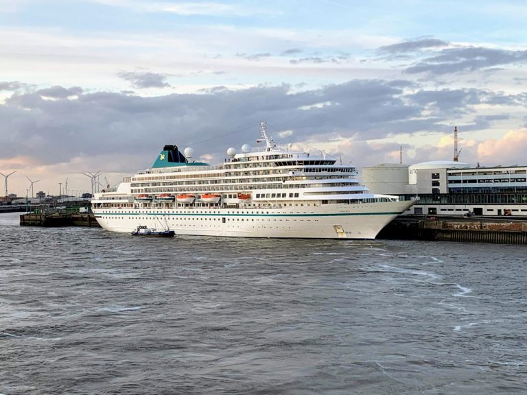 A large cruise ship at a pier in Bremerhaven, Germany, during the day.
